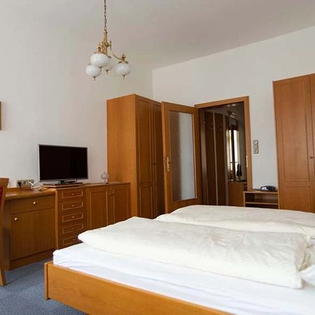 Hotelzimmer mit Doppelbett, Schrankwand, Fernseher und Schreibtisch