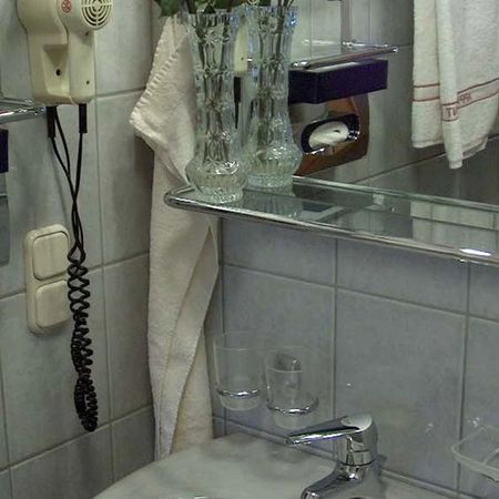 Badezimmer mit Waschbecken, Spiegel, Fön und Handtuchhalter