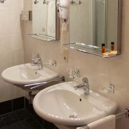 Badezimmer mit zwei Waschbecken, Spiegel und Ablage mit Pflegeprodukten