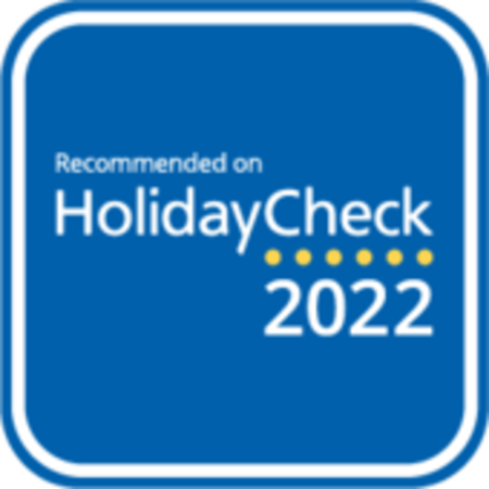 HolidayCheck-Empfehlung 2022 mit fünf gelben Sternen auf blauem Hintergrund.