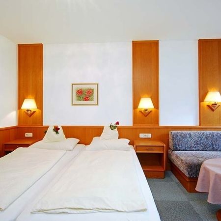 Hotel room with double bed, bedside tables, wall lamps, and sitting area