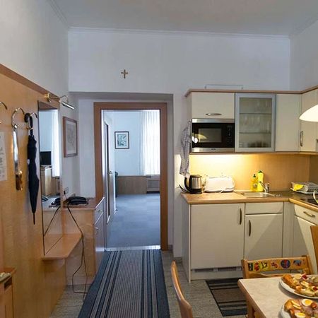 Kitchen area with white cabinets, microwave, and view into the adjoining room