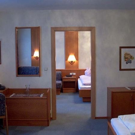 Vista attraverso una porta aperta da una camera d’albergo in un’altra stanza con letto matrimoniale