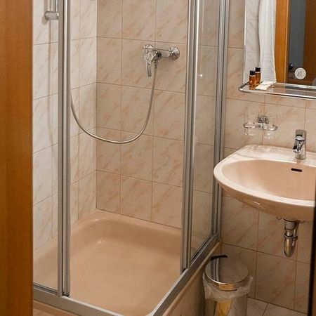 Bagno con doccia, lavabo e specchio