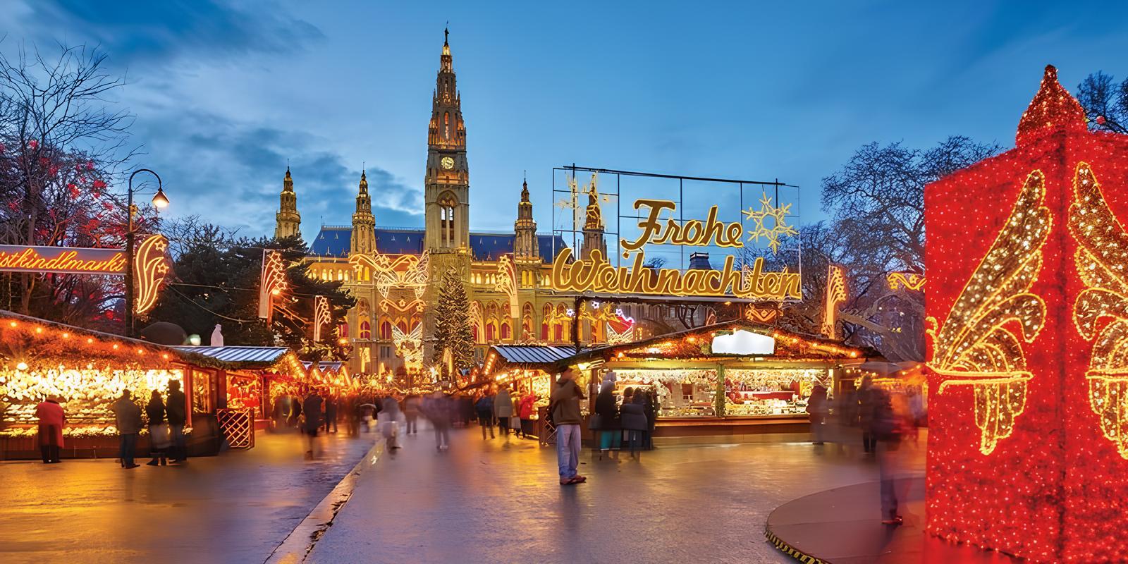 Abendliche Aufnahme des Wiener Christkindlmarktes vor dem Rathaus mit beleuchteten Verkaufsständen und Dekorationen im Vordergrund