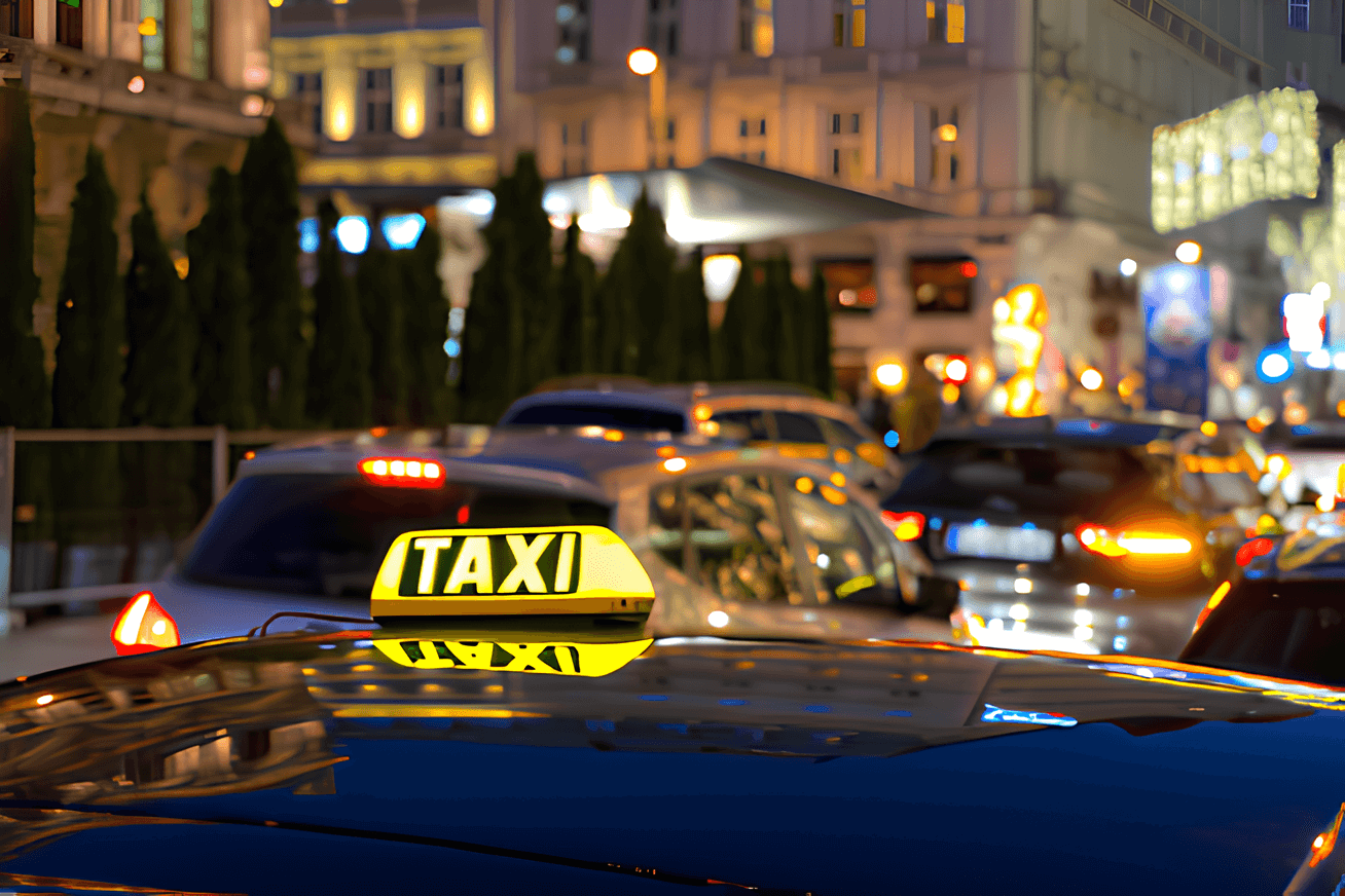 Taxi Zeichen auf dem Dach eines Autos in einer belebten Stadt in der Nacht.