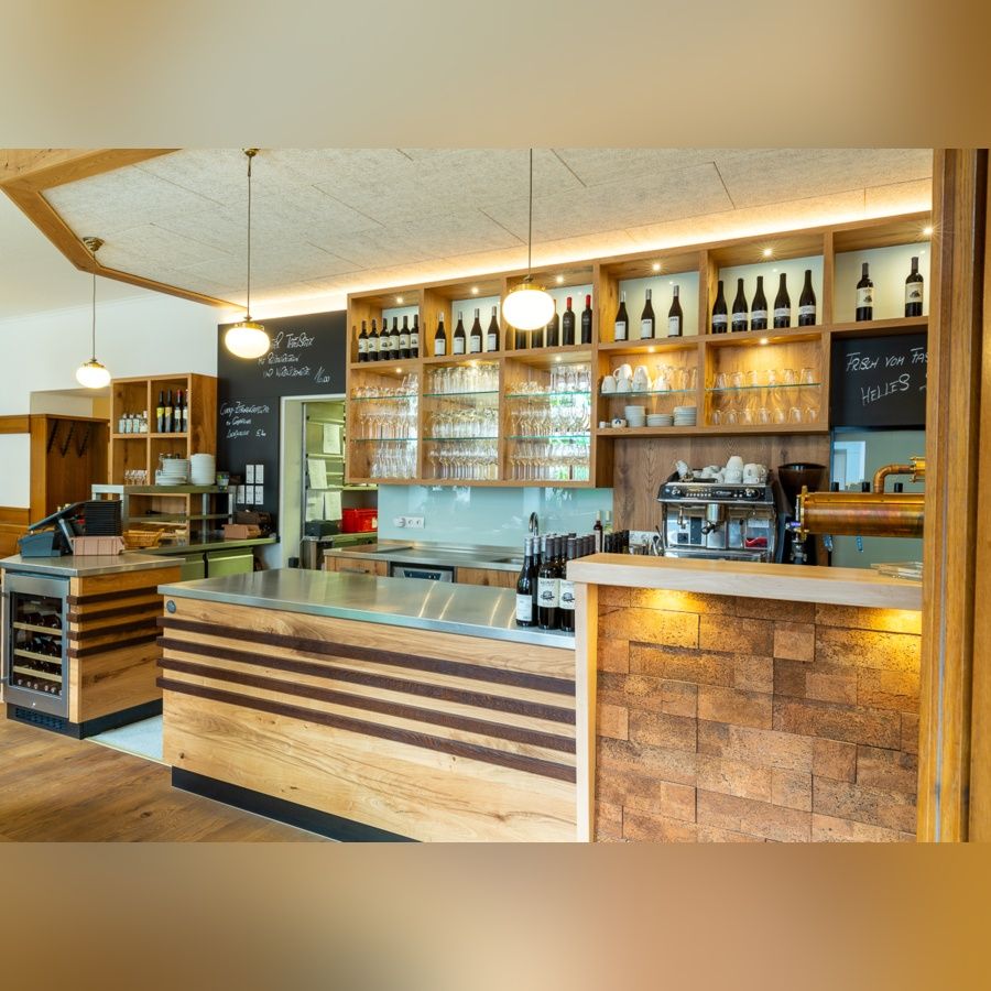 Bedienungstheke in einem Restaurant mit Regalen voller Weinflaschen und Gläser