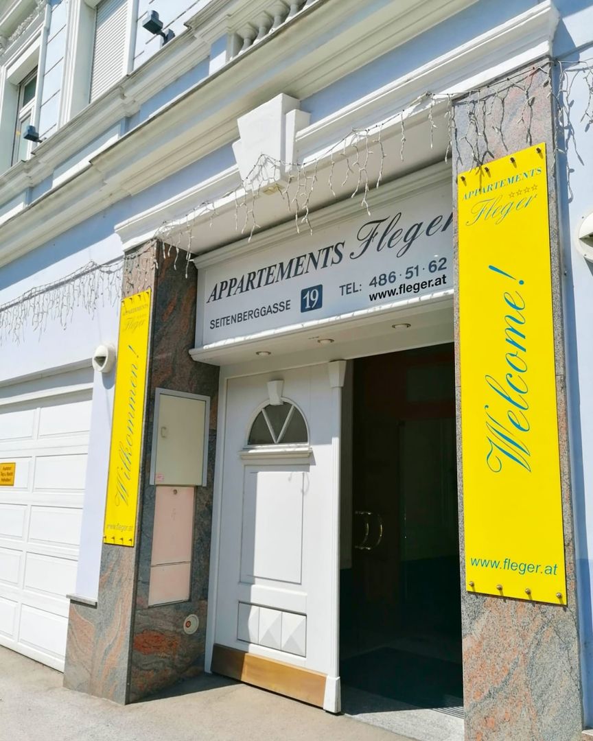 Entrance to Appartements Fleger with yellow sign and lettering above the door