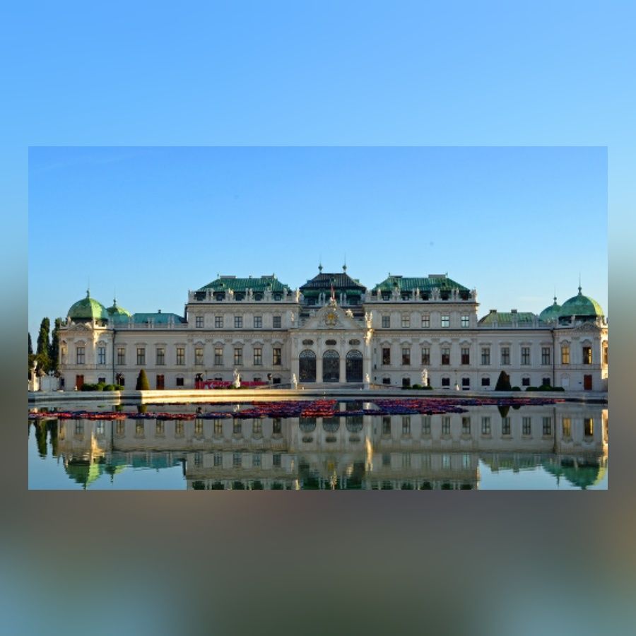 Schloss Belvedere mit seinem Schlossgarten und einer spiegelnden Wasserfläche voller Blumen