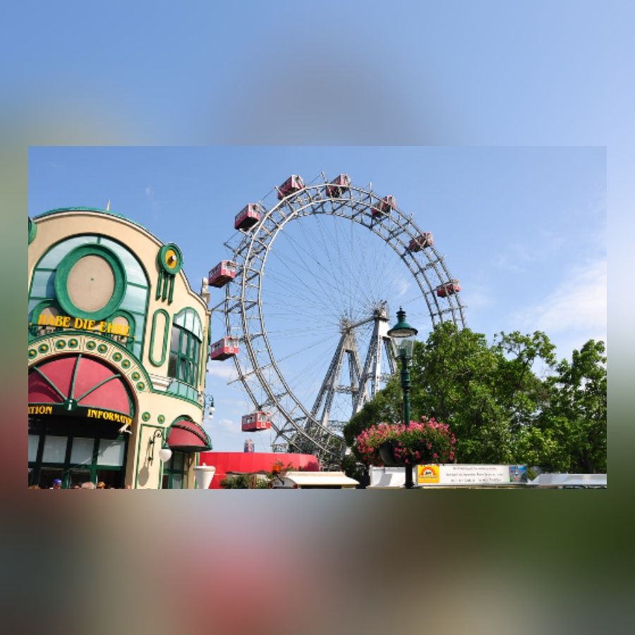 Wiener Riesenrad mit roten Kabinen vor blauem Himmel