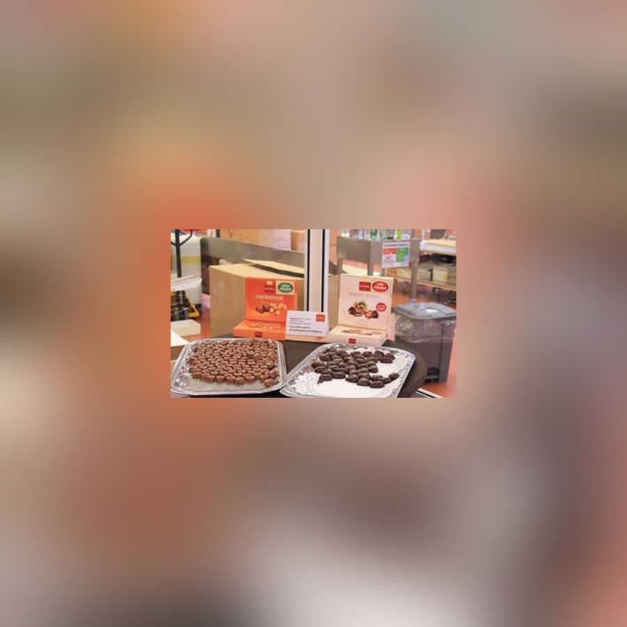 Präsentation von Pralinen und Schokoladenprodukten auf zwei Tellern mit Verpackungen im Hintergrund.