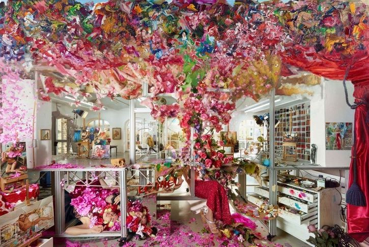 Gemälde eines Ateliers mit verschwommenen Spiegelungen und großen Blumenarrangements die von der Decke fallen und den Raum füllen